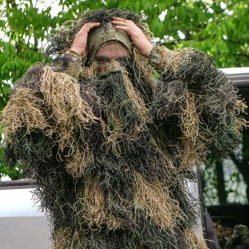 An observer adjusting the full-coverage boonie hat with a built-in see-through front face veil for complete head and facial feature concealment.
