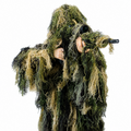 A professional observer wearing GhillieLabs Pro-Series 4-Piece Camouflage System in Woodland Forest pattern, holding a camo-wrapped long-focus telephoto camera lens.
