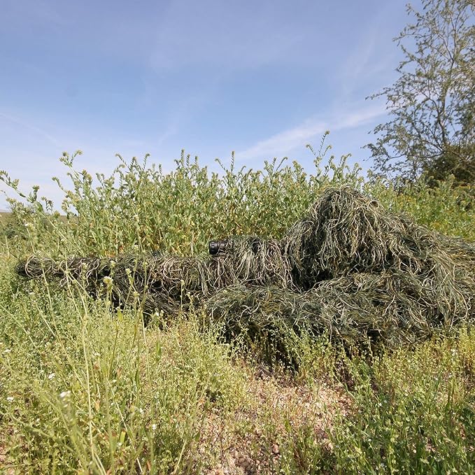 Flawless environmental blending shown by a wildlife photographer lying prone in dense vegetation using the water-resistant and mold-resistant synthetic thread suit.