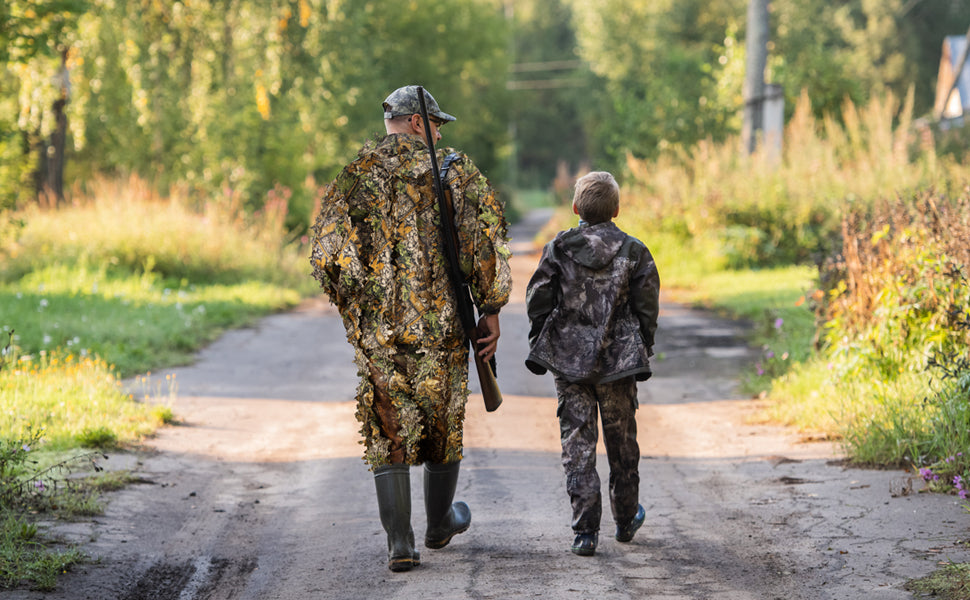 Two outdoor enthusiasts conducting deep wilderness tracking on a forest path while wearing weather-resistant 3D camouflage apparel.