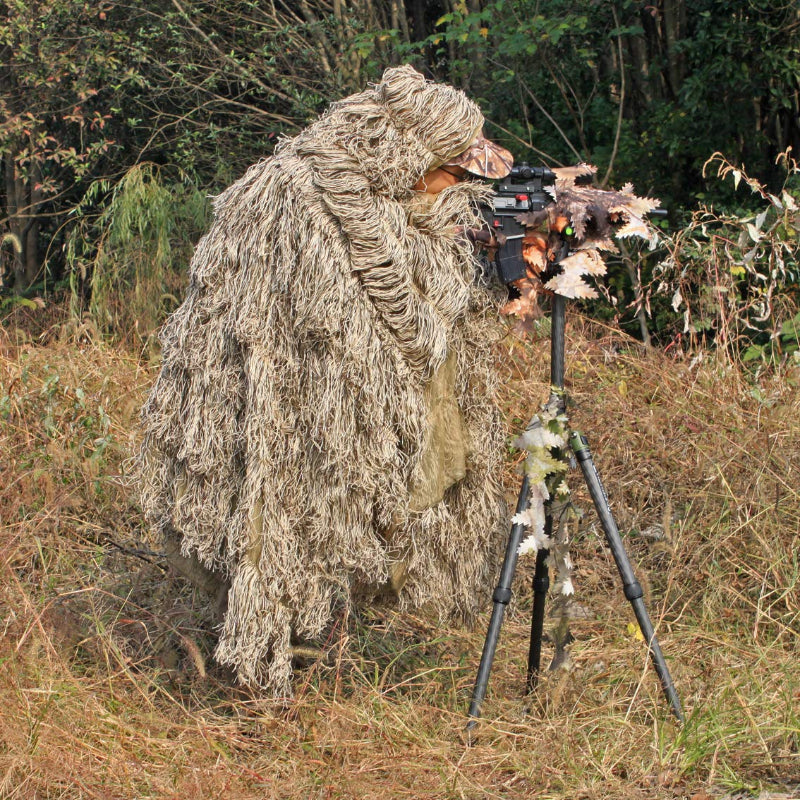 Wildlife photography camouflage setup featuring the Dry Grass Ghillie Poncho worn by a photographer with a telephoto lens on a tripod