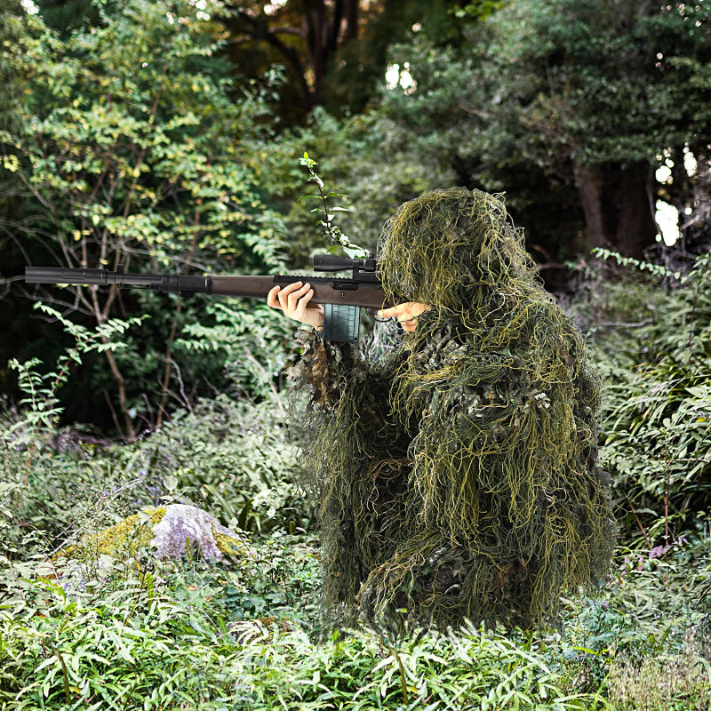 Low-angle view of the Green Woodland Hybrid Ghillie Suit demonstrating how the 3D foliage breaks up the human head and shoulder silhouette in forest shadows.